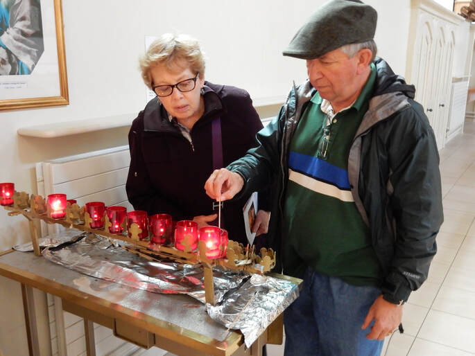 Kate and Mike light candles on behalf of Mike D. in St. Matthew’s RC Church in Belfast, Northern Ireland. 