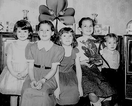   Kate (second from left) and her four siblings celebrating their Irish Ancestry on a St. Patrick’s Day long ago.
